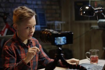 پسر نوجوانی در حال صحبت جلوی دوربین و یوتیوبری