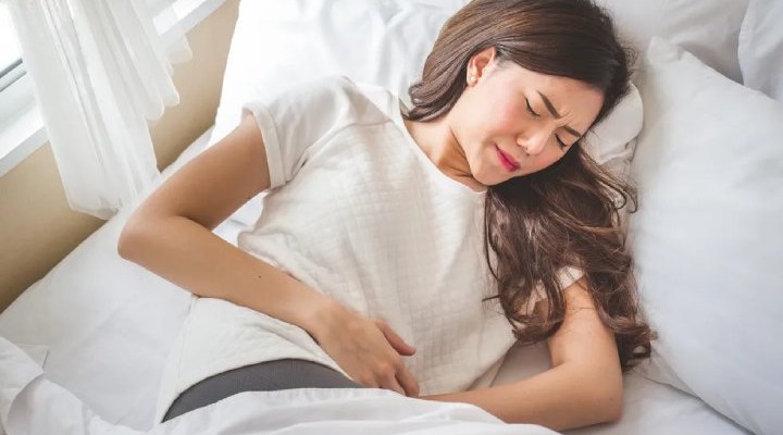 دختری که دچار درد شکمی شدید شده است - علائم منوراژی