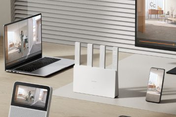 یک روتر در مرکز و اطرافش گوشی و اپ تاپ و مانیتور قرار دارد